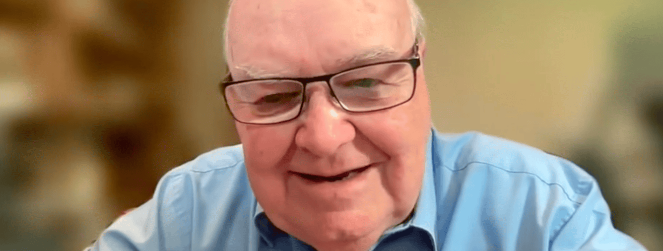 Close-up of an elderly man with glasses smiling, representing community engagement at Katoomba Christian Convention.