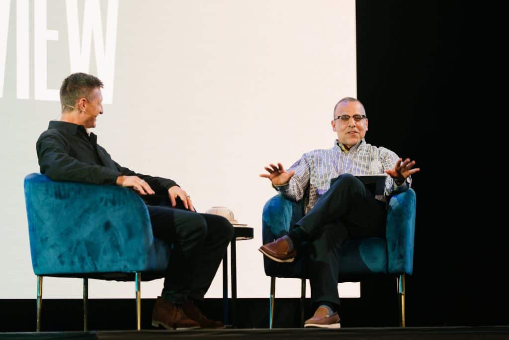 Two men engaged in a discussion on stage at KCC's 'Fear Not' event during KEC 2026, promoting faith and community at the Christian convention.