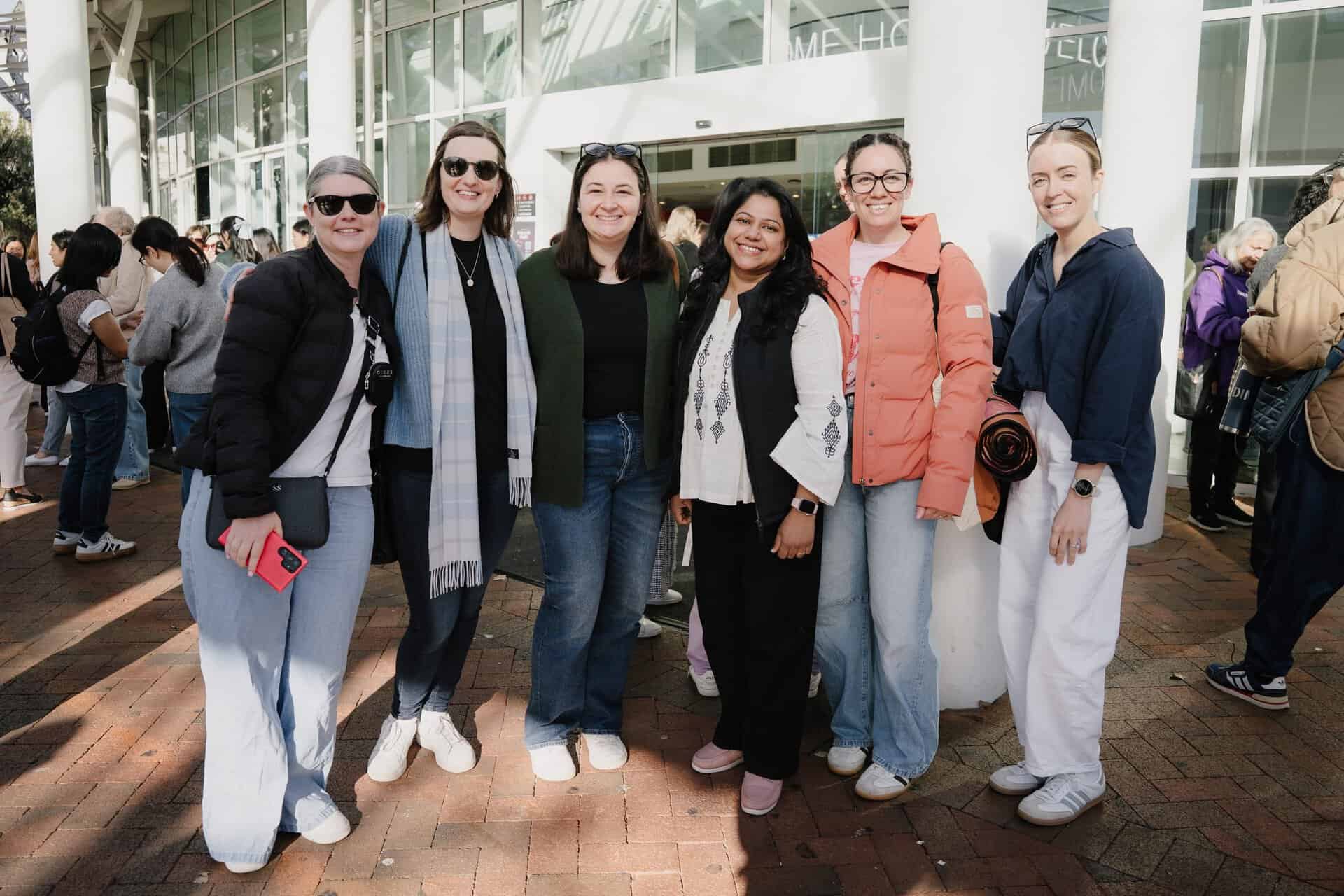 Group of women smiling at the OneLove event in Katoomba, Australia, promoting trust and spiritual growth among women.